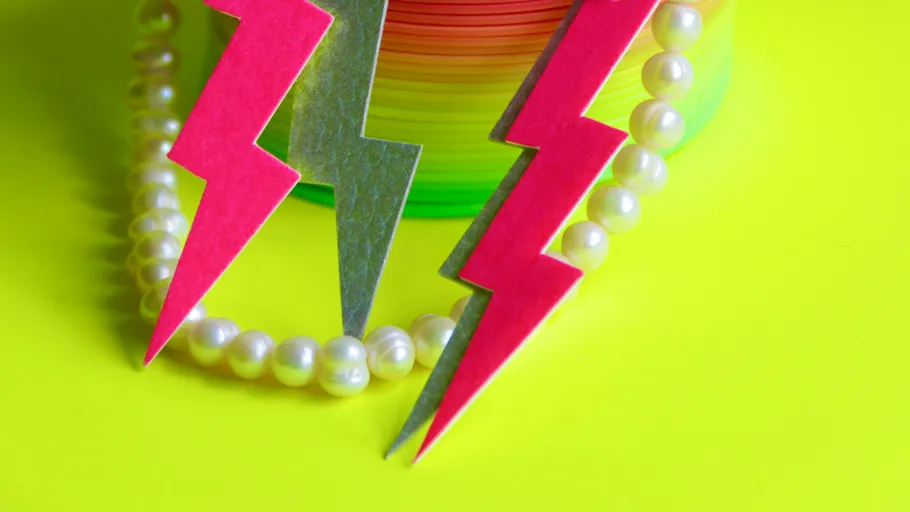 Lightning shapes beside pearls on yellow background.