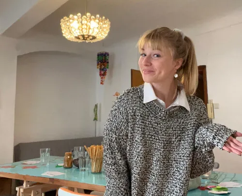 Person im gemütlichen Innenraum zuckt mit den Schultern.