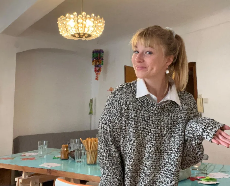 Person shrugging in a cozy interior setting.