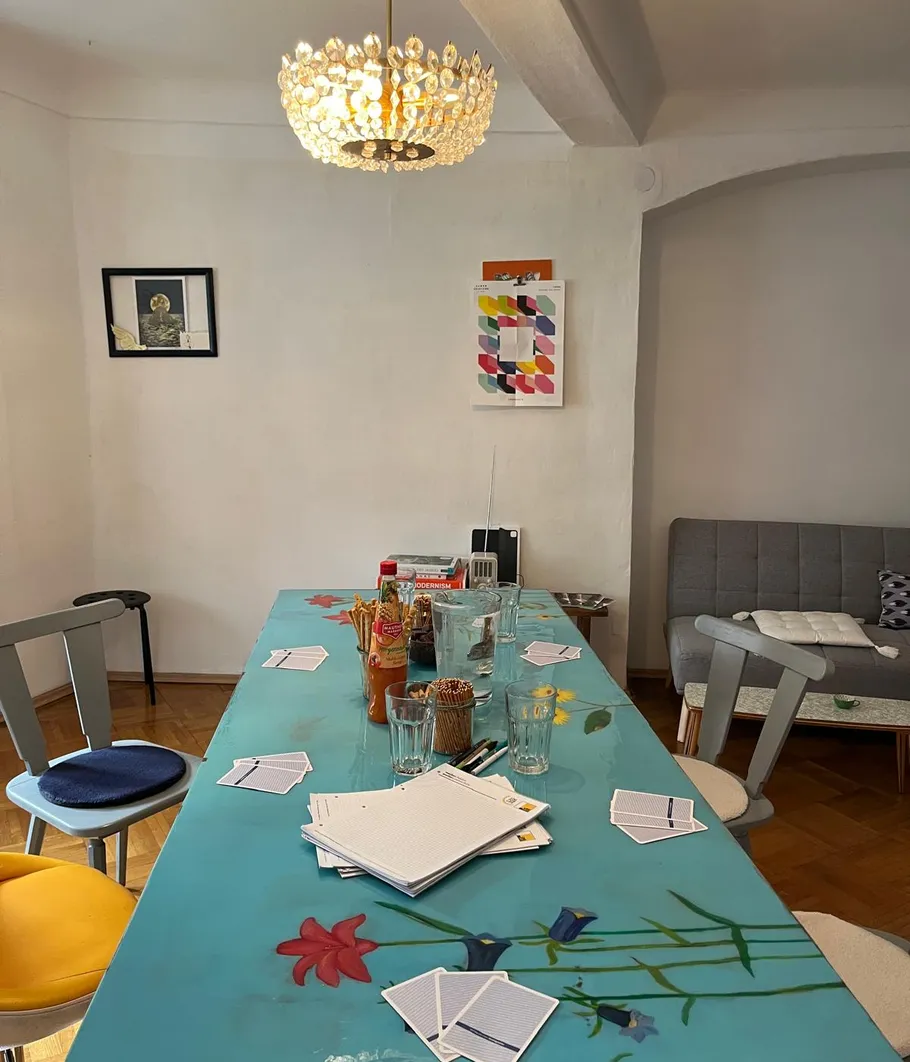 Esstisch mit Karten und Gläsern im Raum.