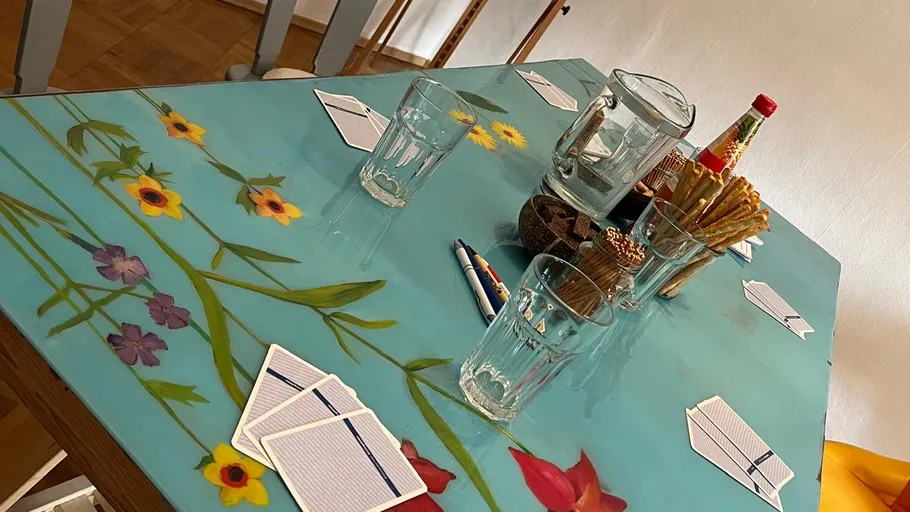 Decorated table set with glasses, cards, and snacks.