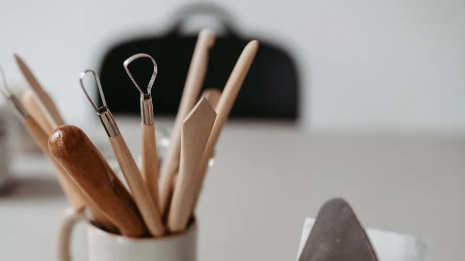 Pottery tools in a holder on table.