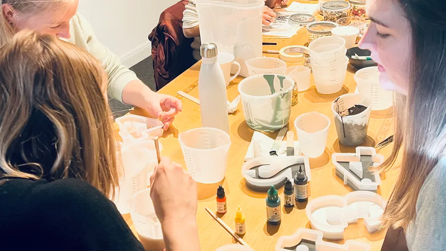 People crafting at a table with supplies.