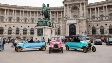 Oldtimer vor historischem Gebäude geparkt.