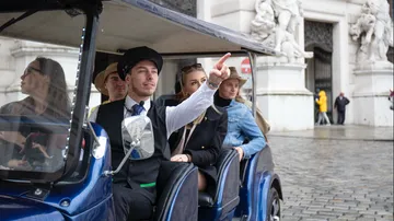 Tour guide pointing in street vehicle.