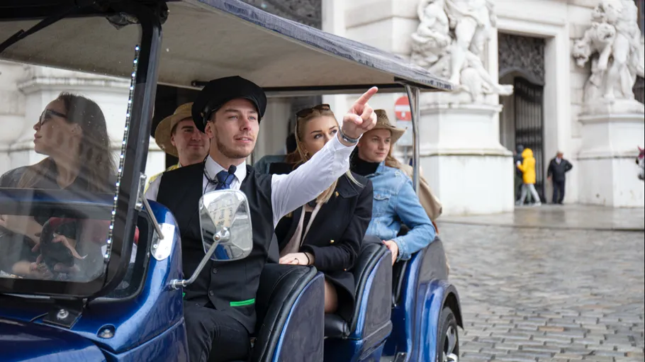 Tour guide pointing in street vehicle.