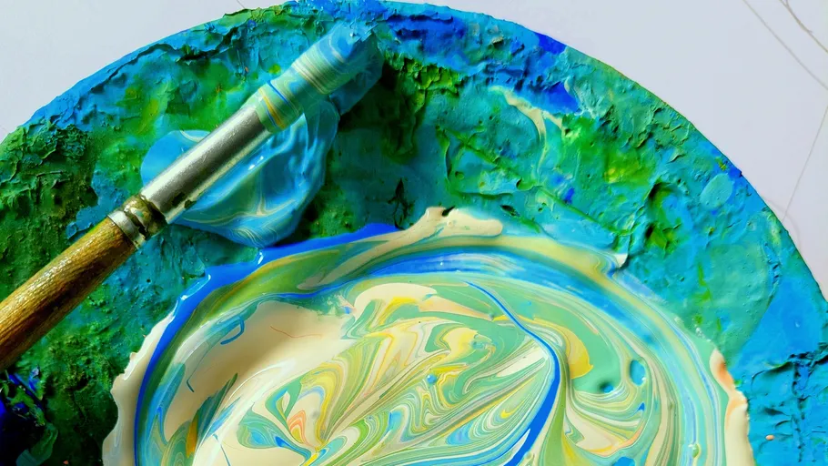 Brush with mixed paint on a palette.