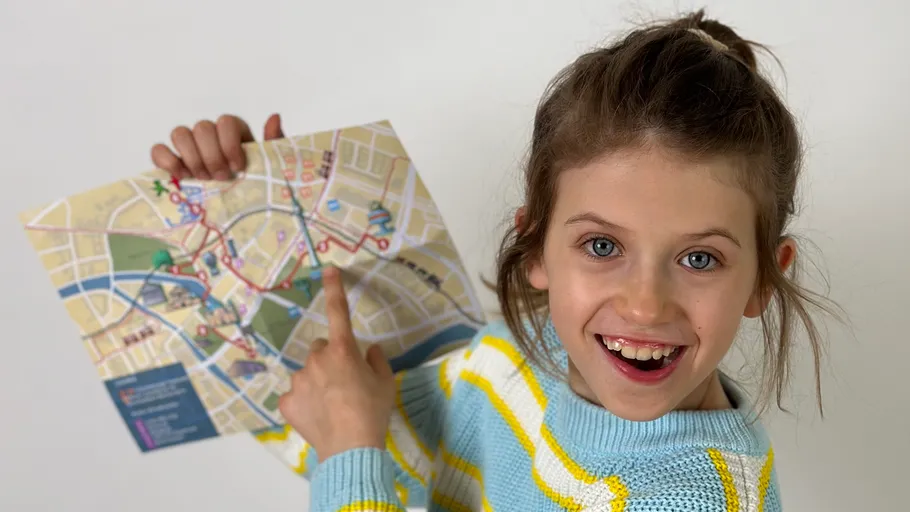 Girl happily points at a map.