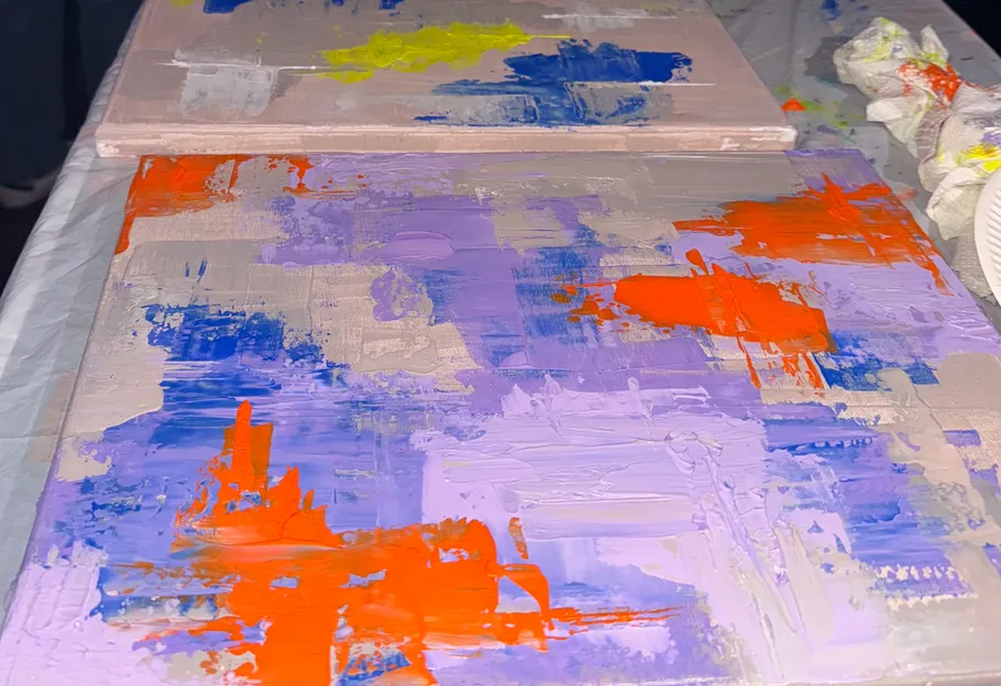 Abstract paintings with colorful brushstrokes on table.