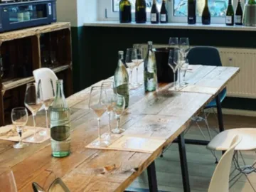 A wooden table is covered with glasses and bottles of water.