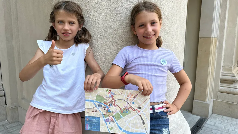 Two girls smiling, holding a city map.