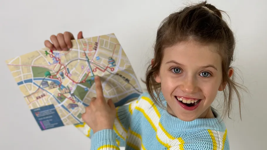 Girl holding and pointing at a city map.