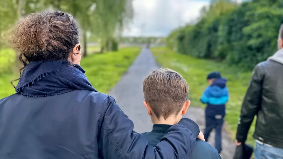 Familie spaziert auf einem Landweg.