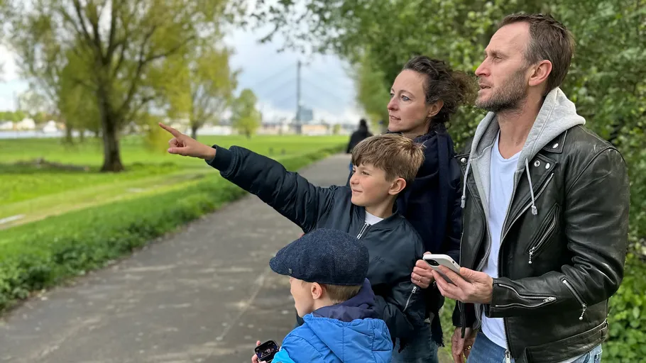 Family looking and pointing in green park area.