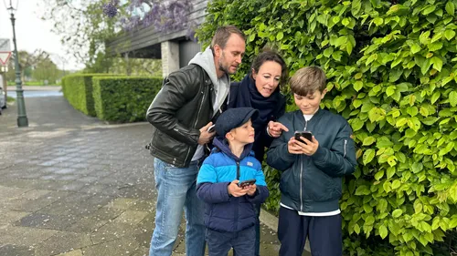 Family looking at a smartphone outside.