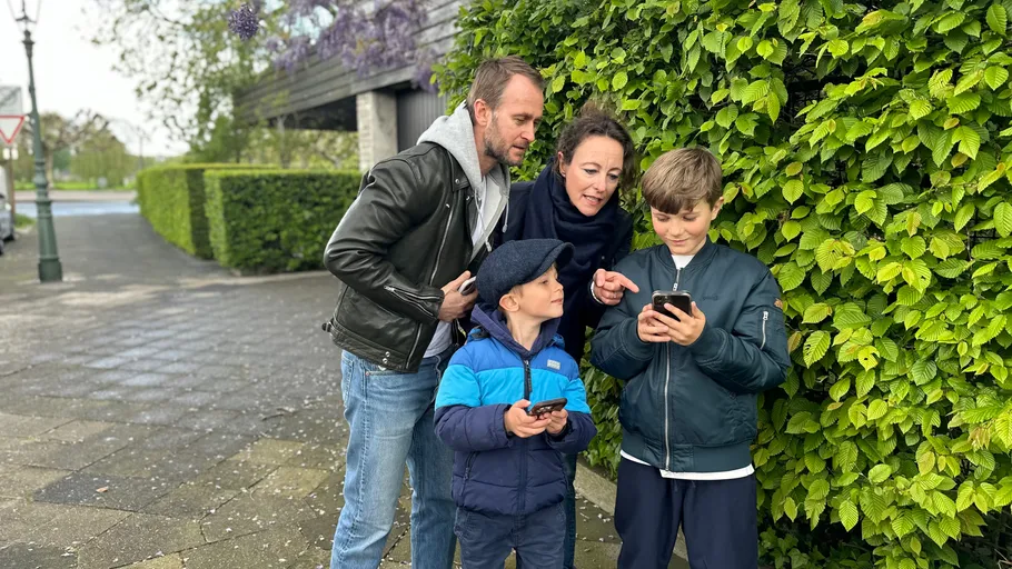 Family looking at a smartphone outside.
