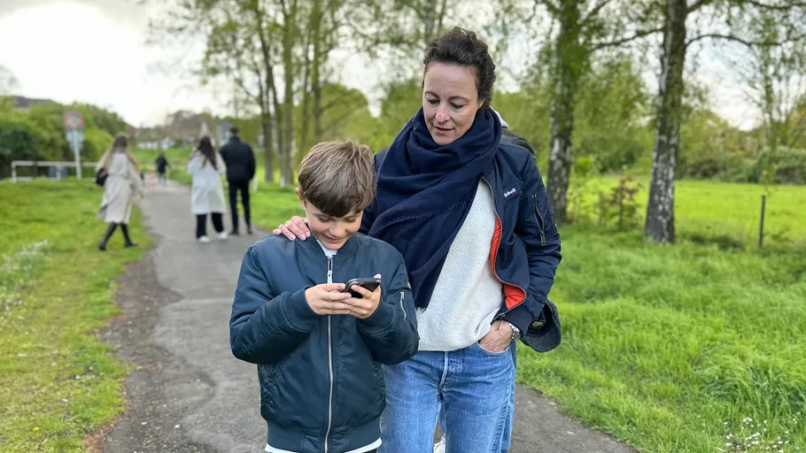 Frau und Junge spazieren auf Parkweg.