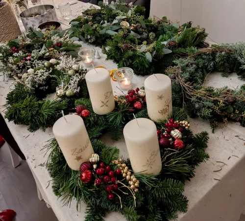 Festive wreaths with candles on table.
