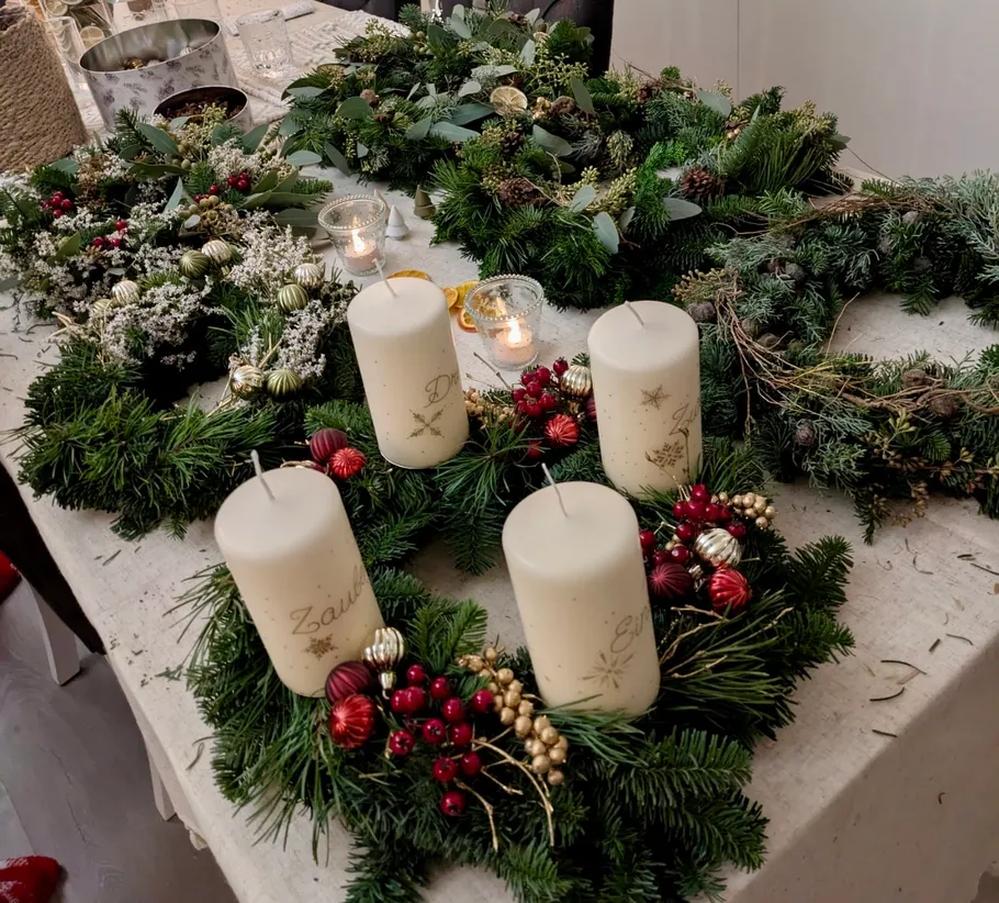Festive wreaths with candles on table.