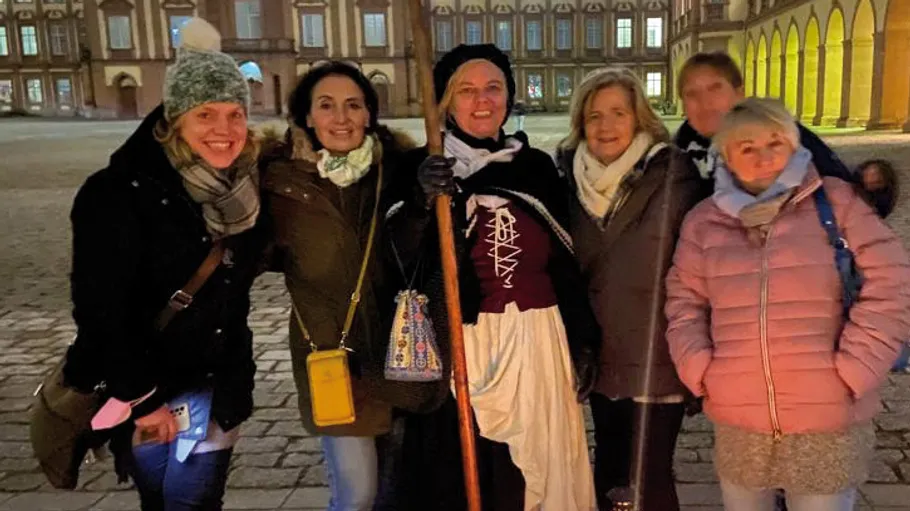 Group posing with lantern, castle in background.