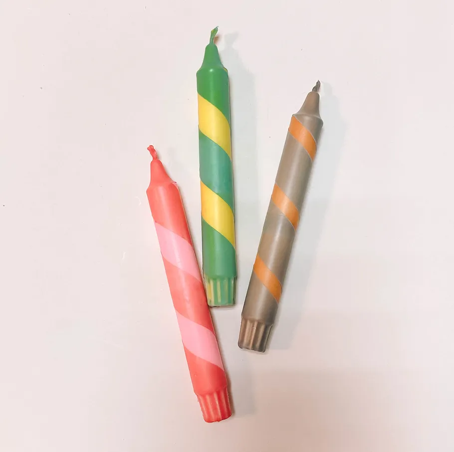 Three striped crayons on white background.