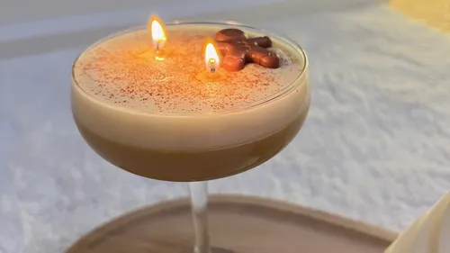 Cocktail with lit candles in a glass.