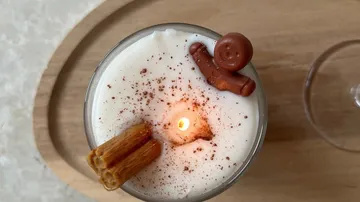 Brennende Kerze mit Zimt und Lebkuchen.
