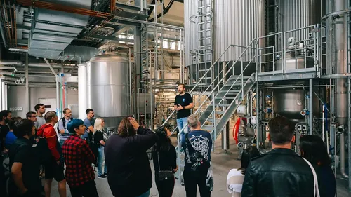 Group touring industrial facility with guide speaking.