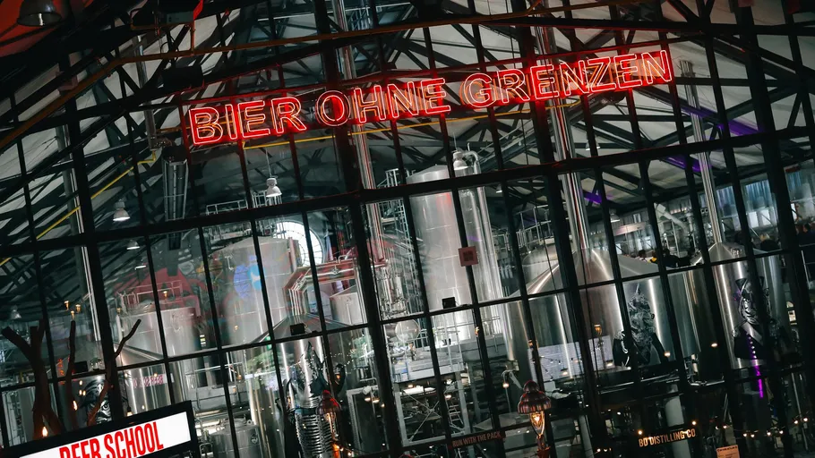 Brewery interior with neon sign 'Bier Ohne Grenzen'.