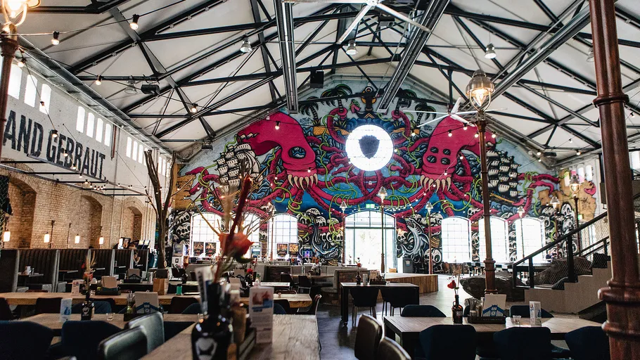 Colorful mural inside industrial-style restaurant.
