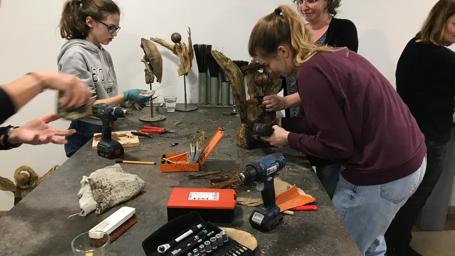 People crafting sculptures in a workshop setting.