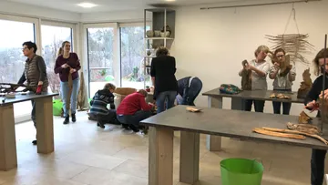 Menschen basteln in einem hellen Raum.