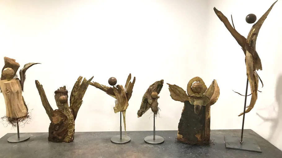 Holzskulpturen auf Ausstellungstisch.