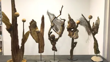 Abstract sculptures made of wood and branches indoors.