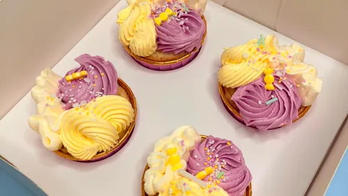 Bunte Cupcakes mit gewirbeltem Zuckerguss in Schachtel.