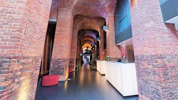 Modern lobby with brick arches and reception desk.