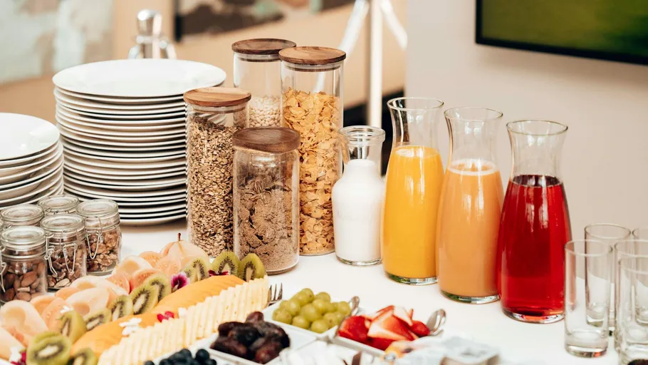Breakfast buffet with cereals, juices, and fruits.