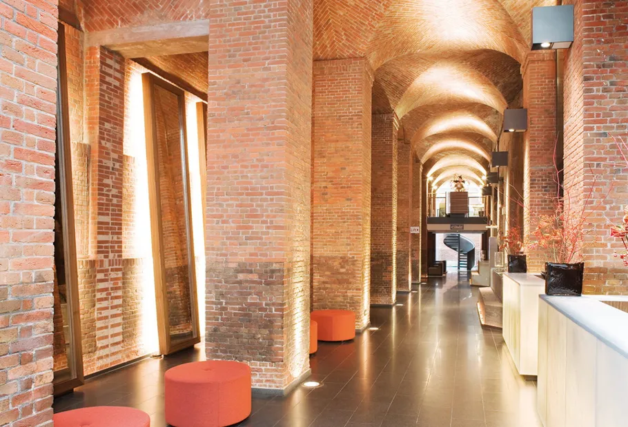 Brick arch hallway illuminated with modern lighting.