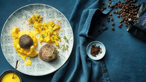Steak and roasted cauliflower on patterned plate.