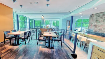 Modernes Restaurantinterieur mit Tischen und Stühlen.