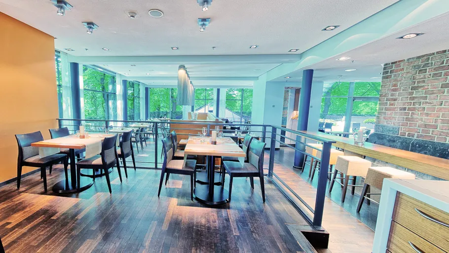 Modernes Restaurantinterieur mit Tischen und Stühlen.