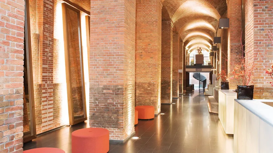 Modern lobby with brick arches and seating.