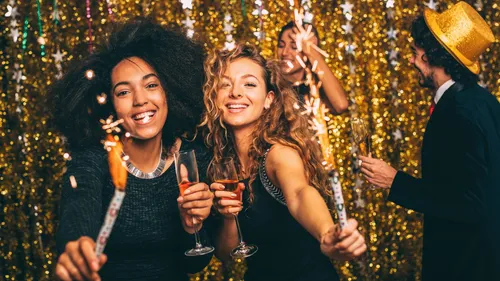 People celebrating with sparklers and glasses.