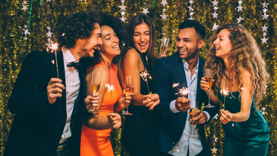 People celebrating with sparklers, wearing formal attire.