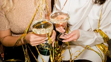 Two women holding champagne glasses at party.