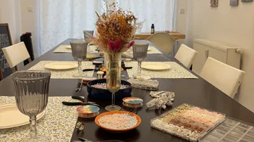 Craft table with beads, flowers, and crafting materials.