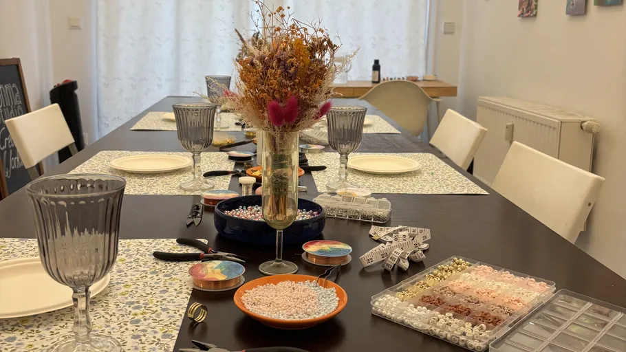 Basteltisch mit Perlen, Blumen und Bastelmaterialien.