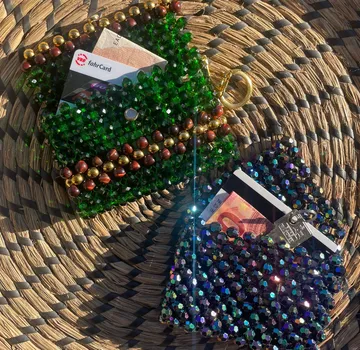 Beaded pouches placed on woven surface outdoors.