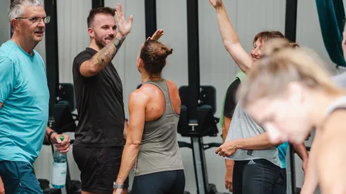Group high-fiving in a gym setting.