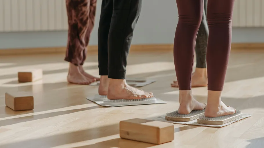 People stand on nail boards during class.